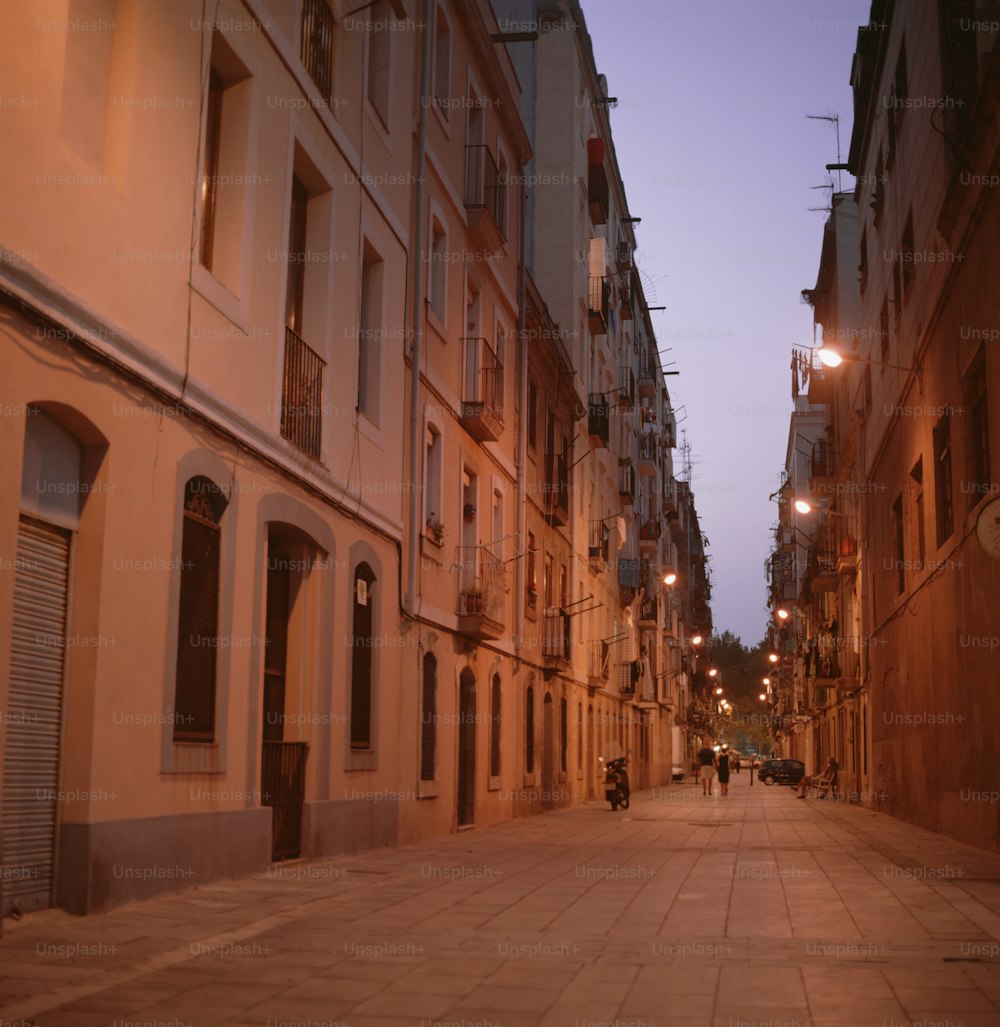 a city street at night with people walking down it