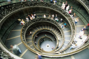 a group of people walking up and down a spiral staircase