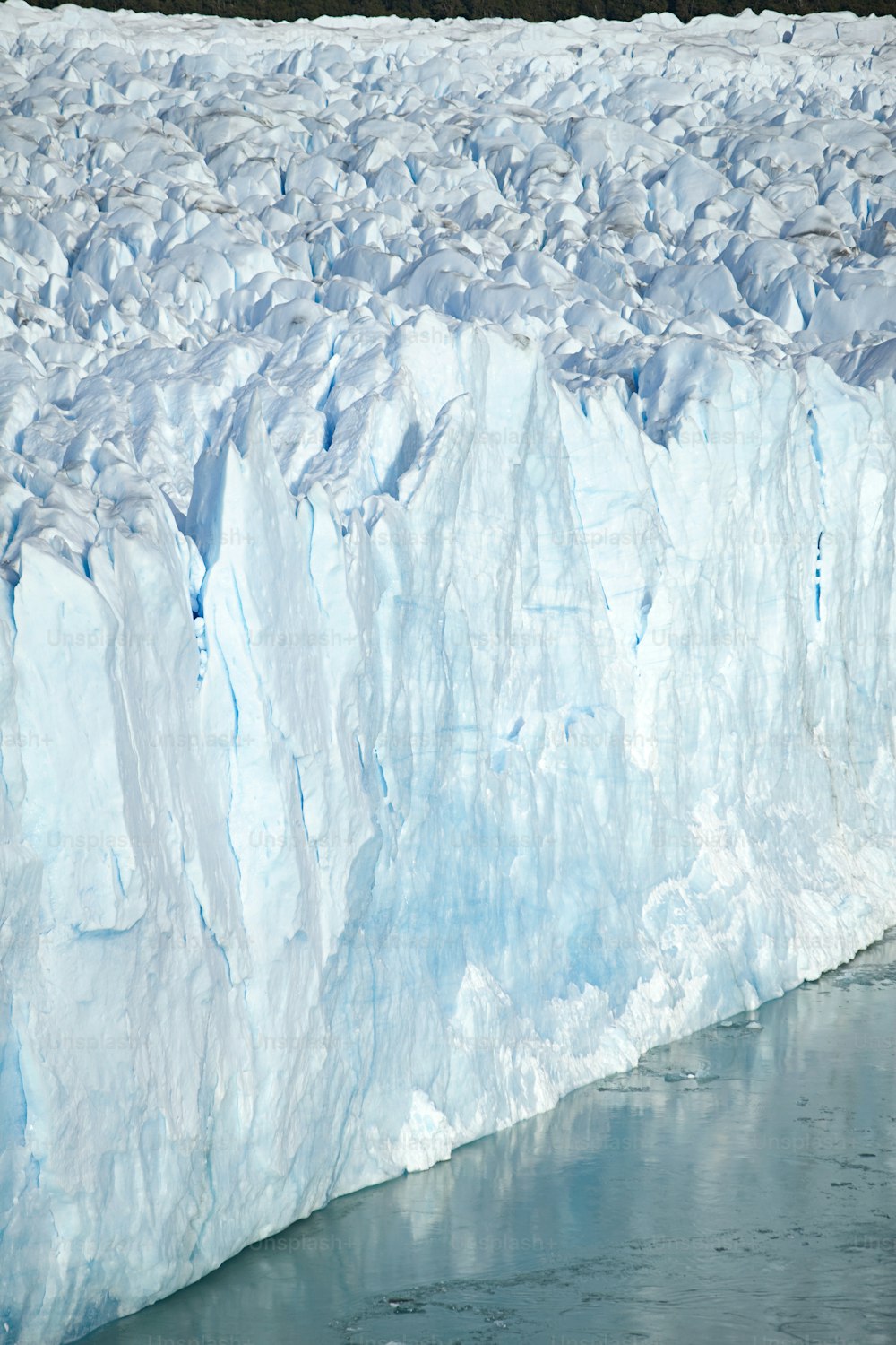 a large iceberg with a man standing on top of it