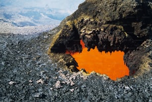 an orange substance in the middle of a rocky area