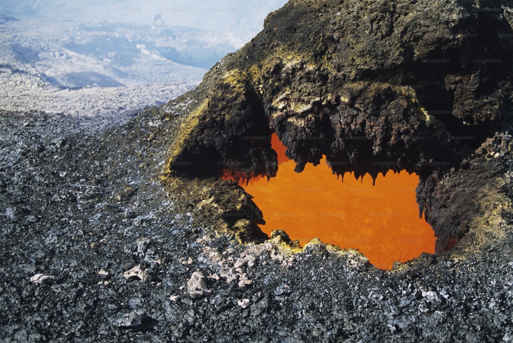 an orange substance in the middle of a rocky area