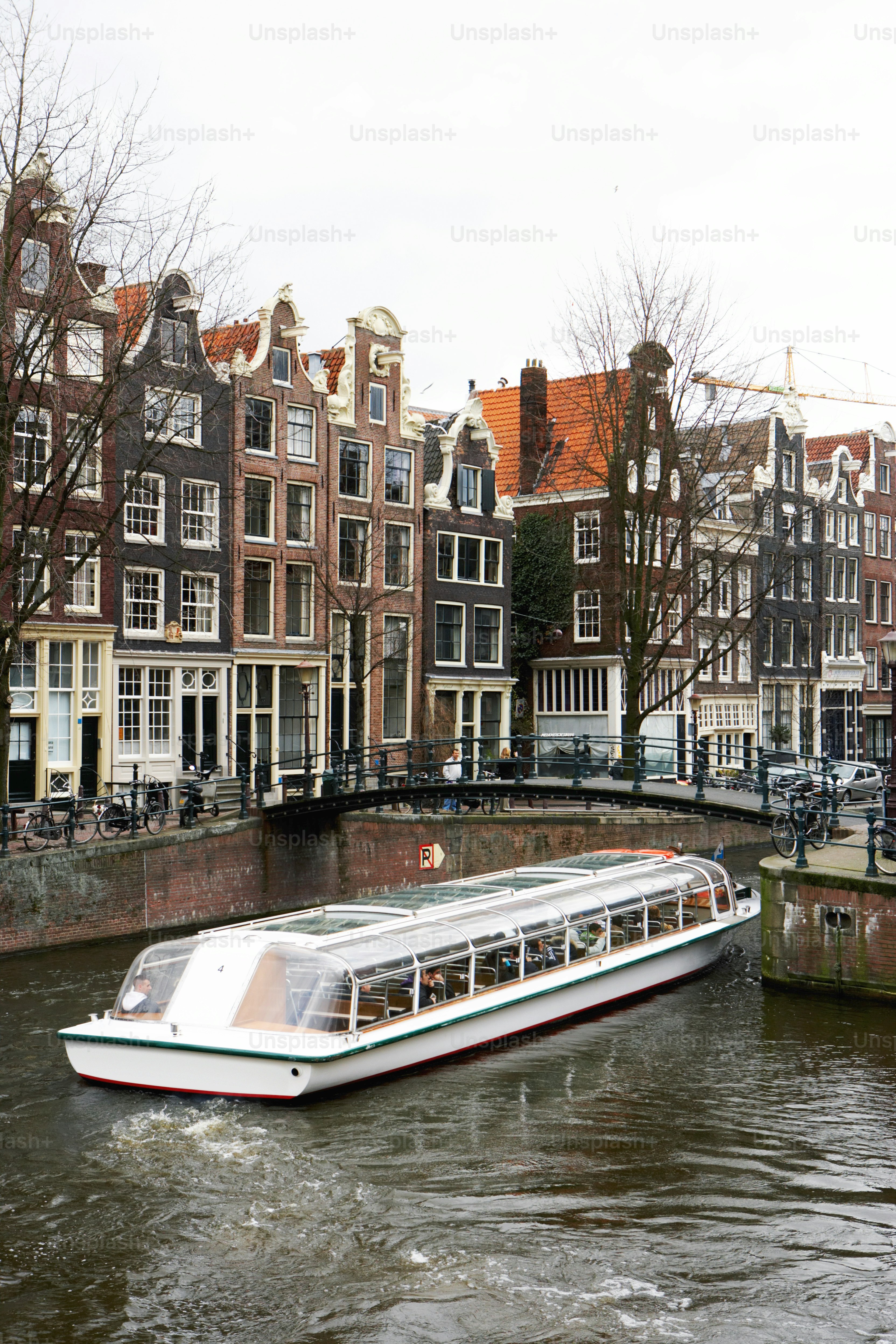 ein Boot, das neben hohen Gebäuden einen Fluss hinunterfährt