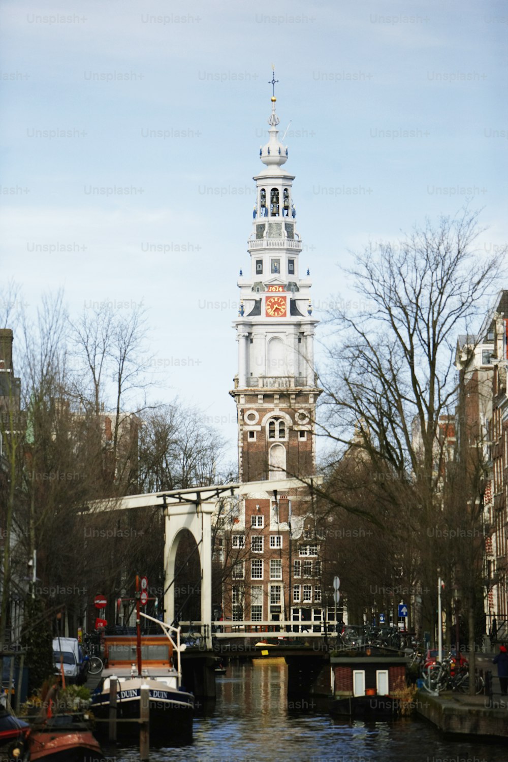 a tall clock tower towering over a city next to a river