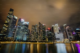 a city at night with lights reflecting in the water