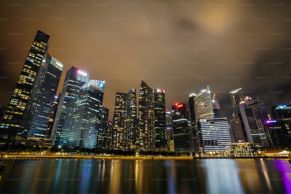 a city at night with lights reflecting in the water