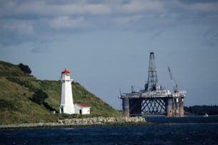 a lighthouse on a hill next to a body of water