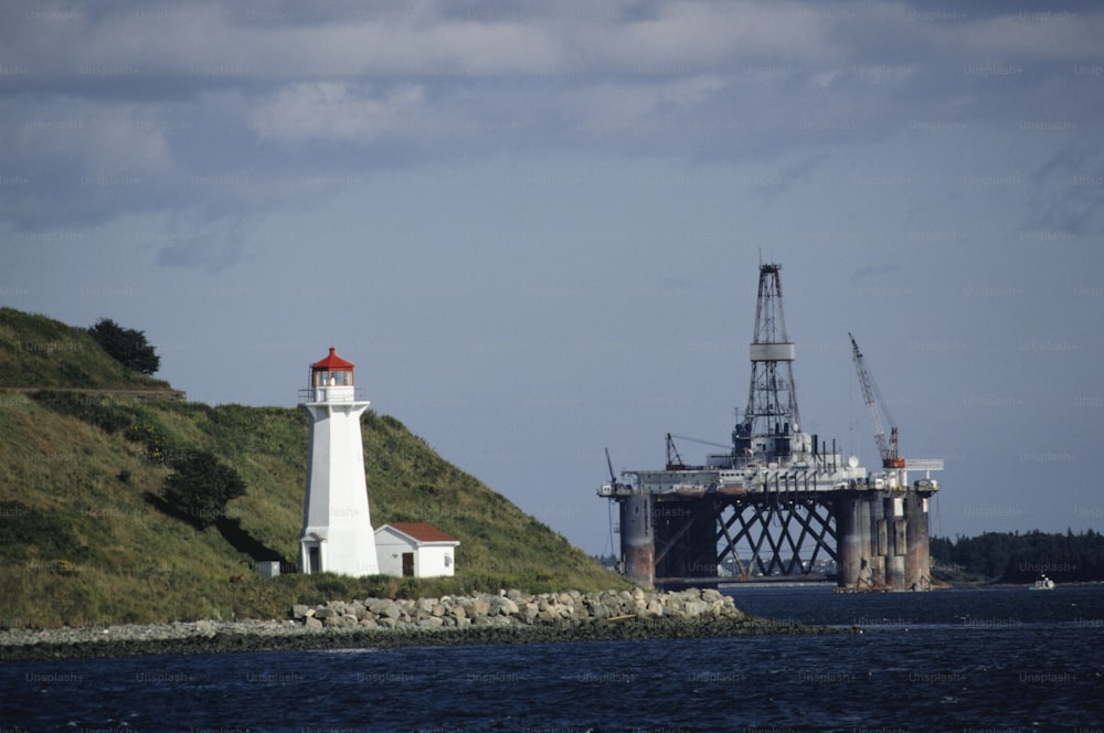 a lighthouse on a hill next to a body of water