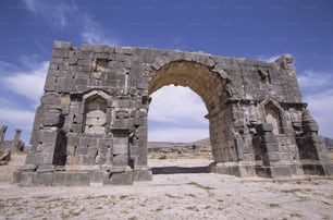 a stone structure with a doorway and a sky background