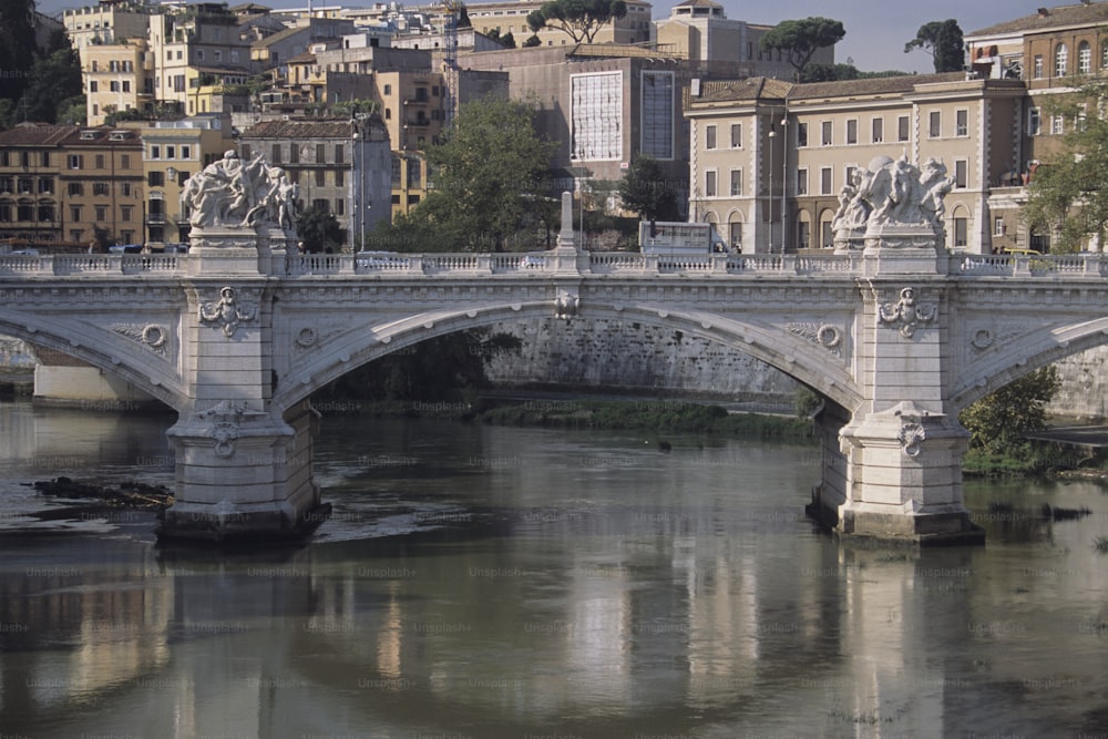 a bridge over a body of water with buildings in the background