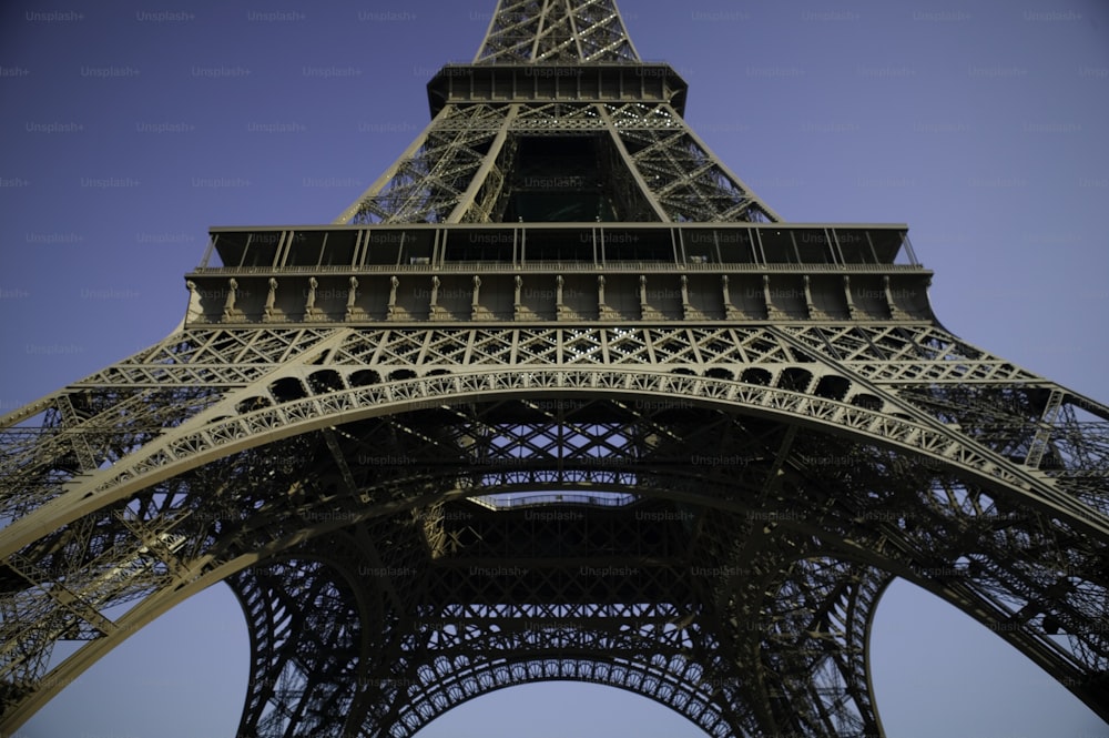 Die Spitze des Eiffelturms vor blauem Himmel