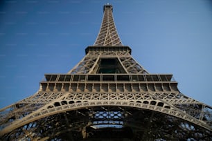 Die Spitze des Eiffelturms vor blauem Himmel