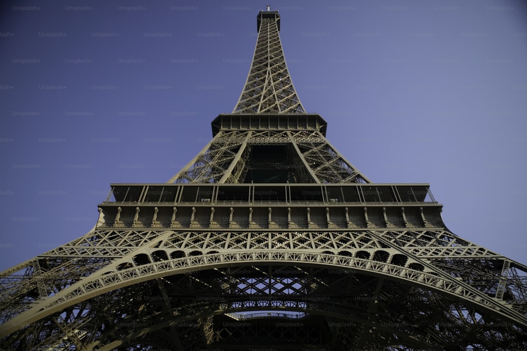 the top of the eiffel tower against a blue sky