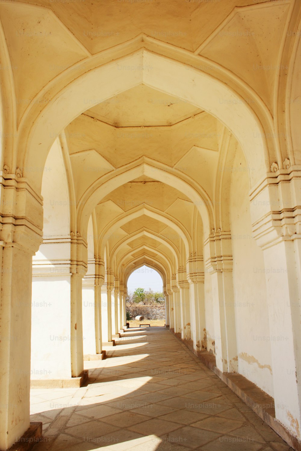 a walkway lined with arches and pillars in a building