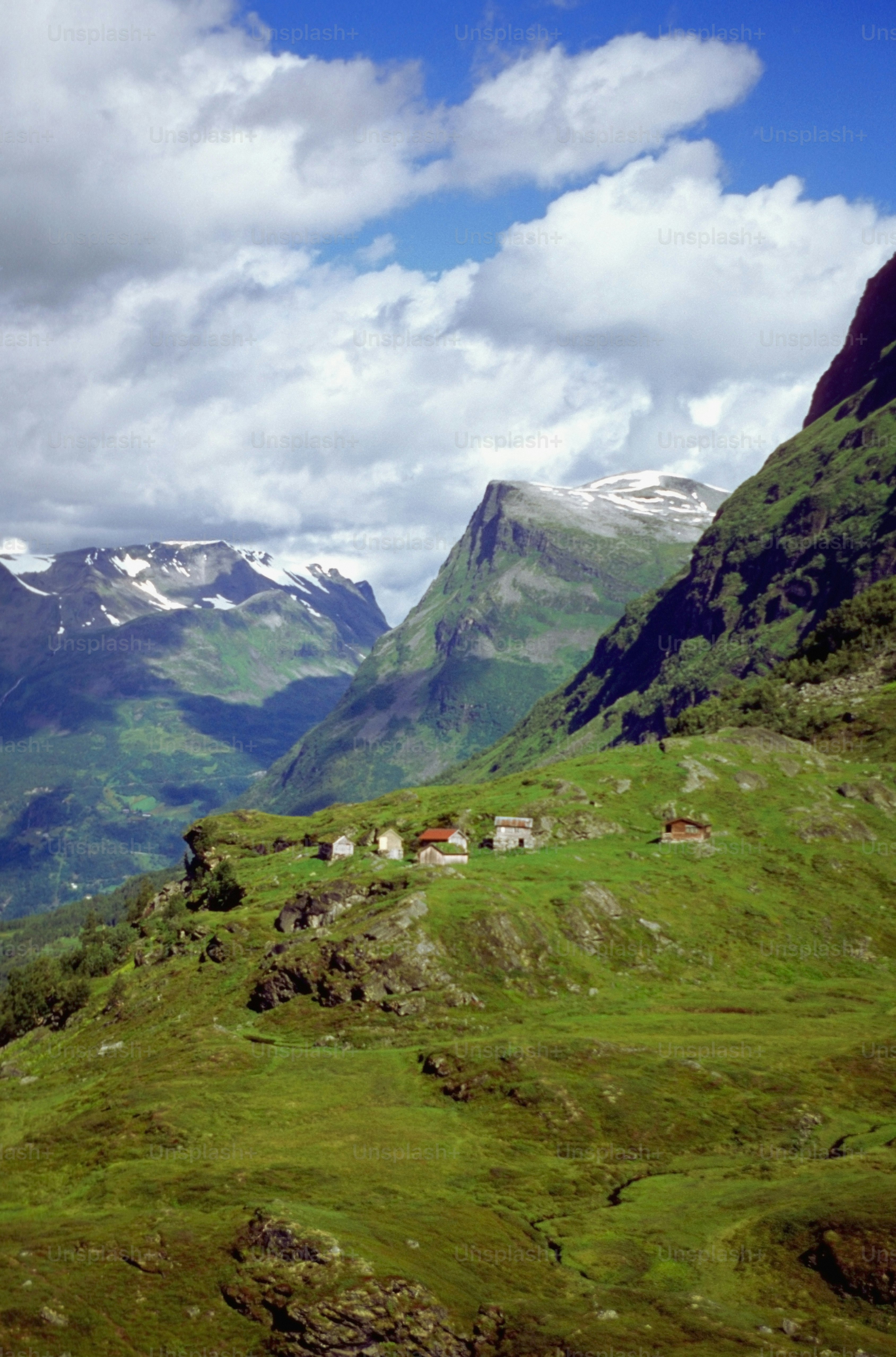 a green valley with mountains in the background