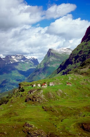 a green valley with mountains in the background