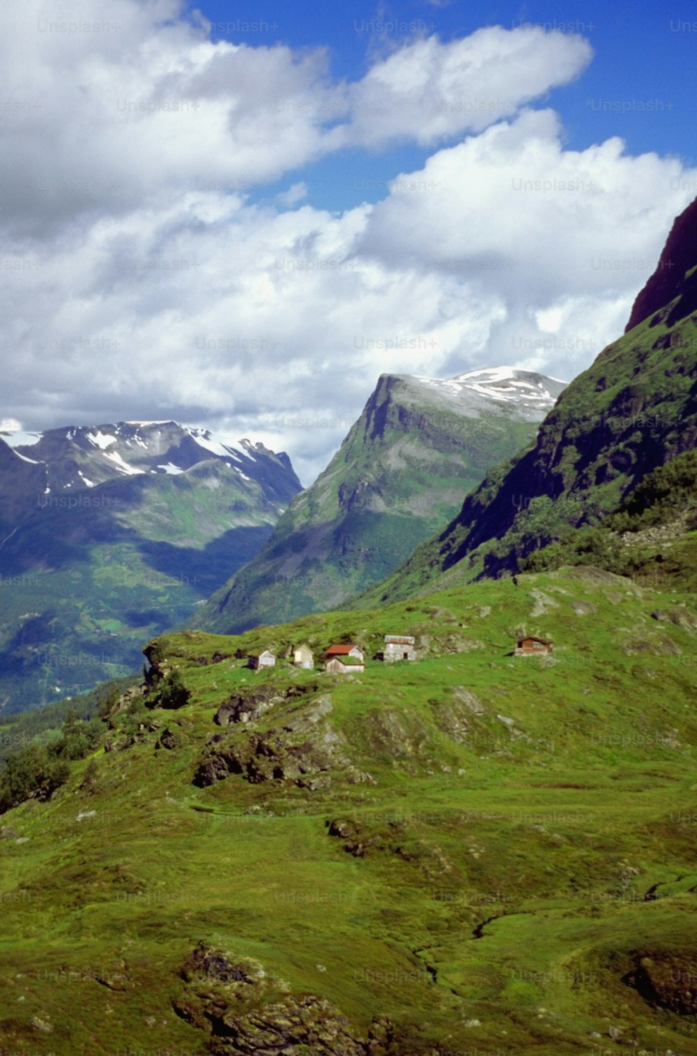 a green valley with mountains in the background