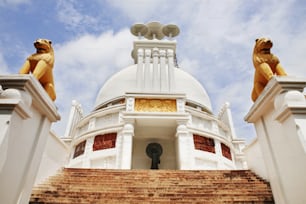 um edifício branco com dois leões dourados em cima dele