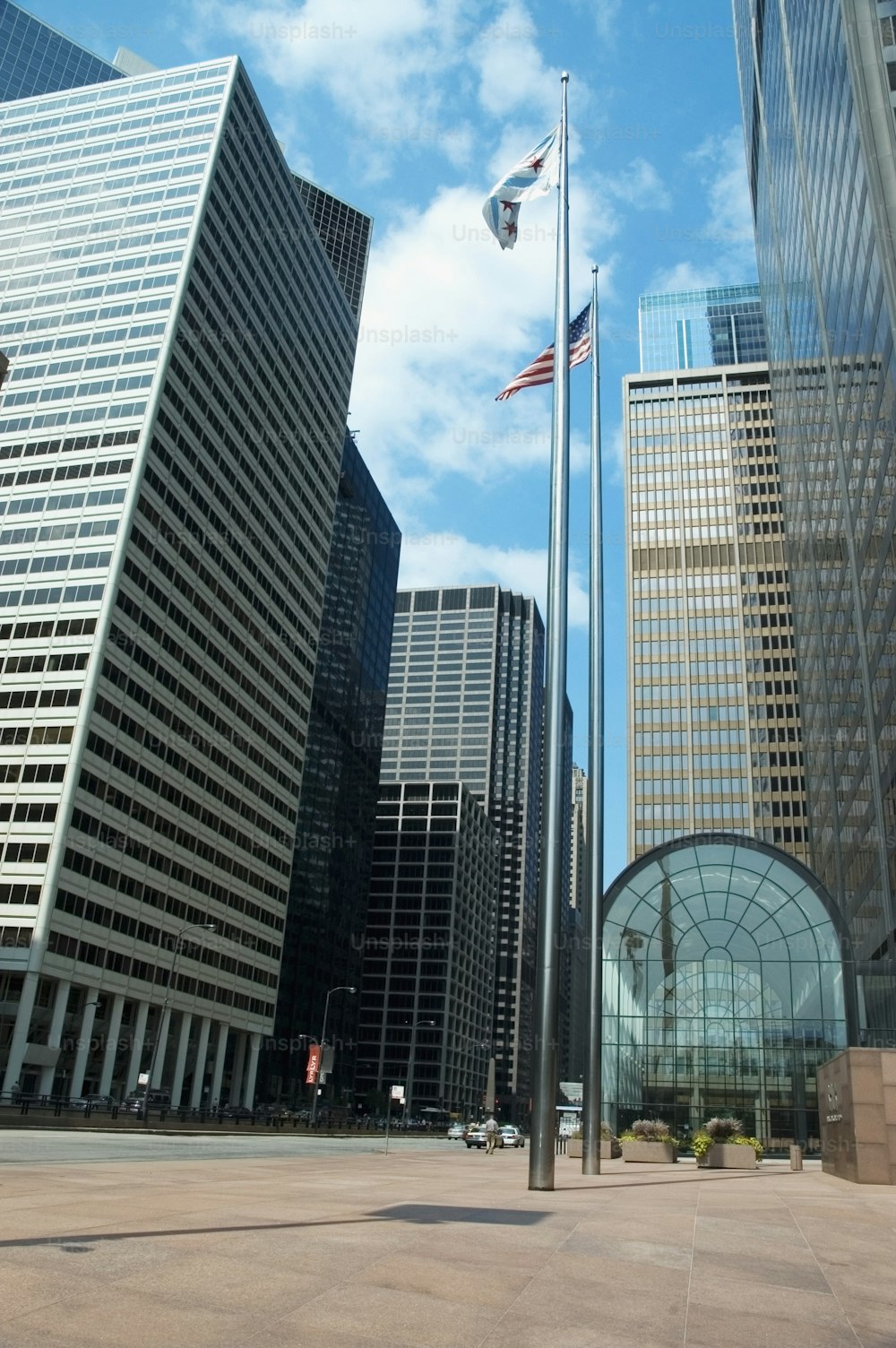 a city street with tall buildings and a flag pole