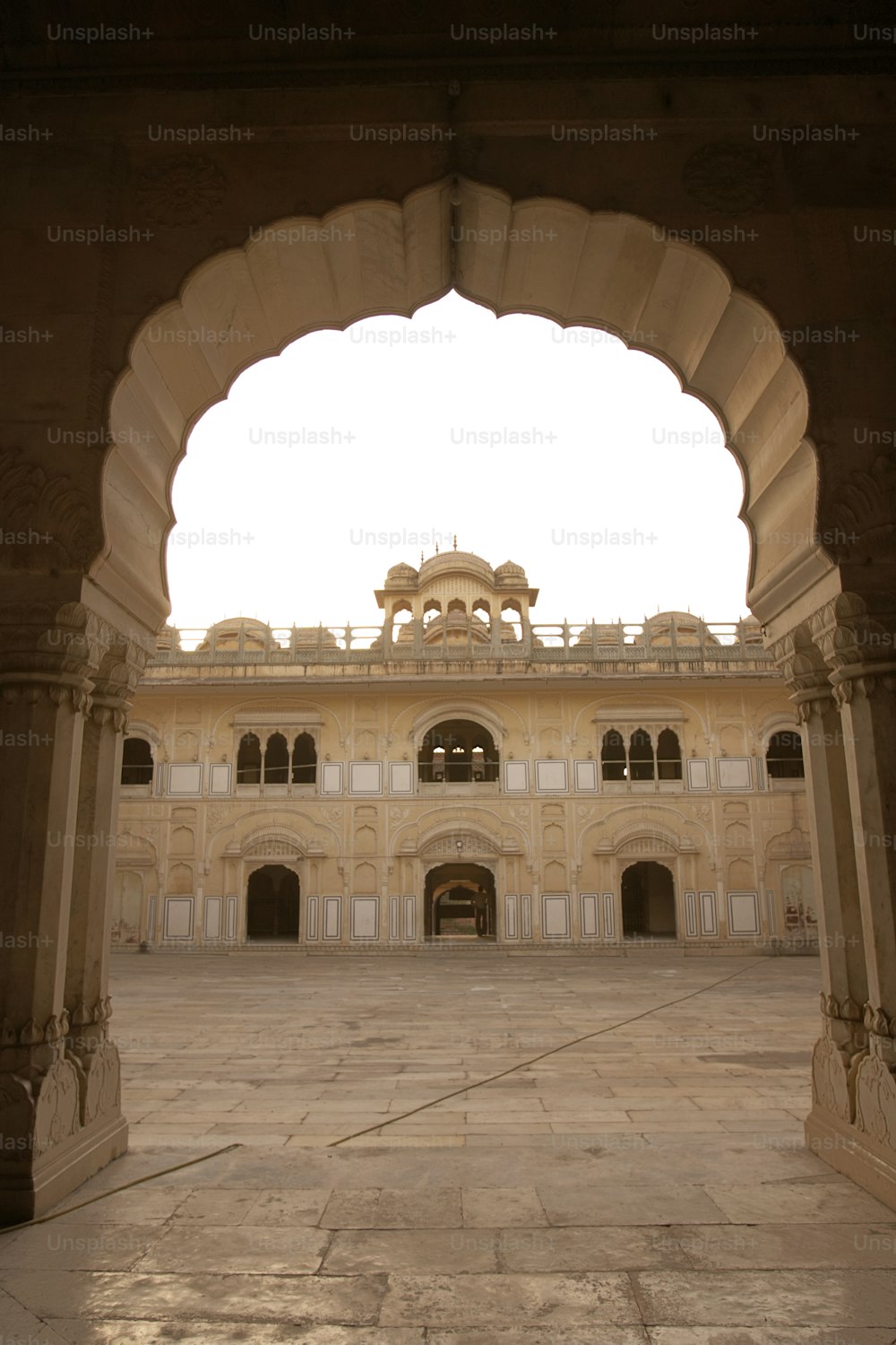 a building with arches and a clock tower in the background