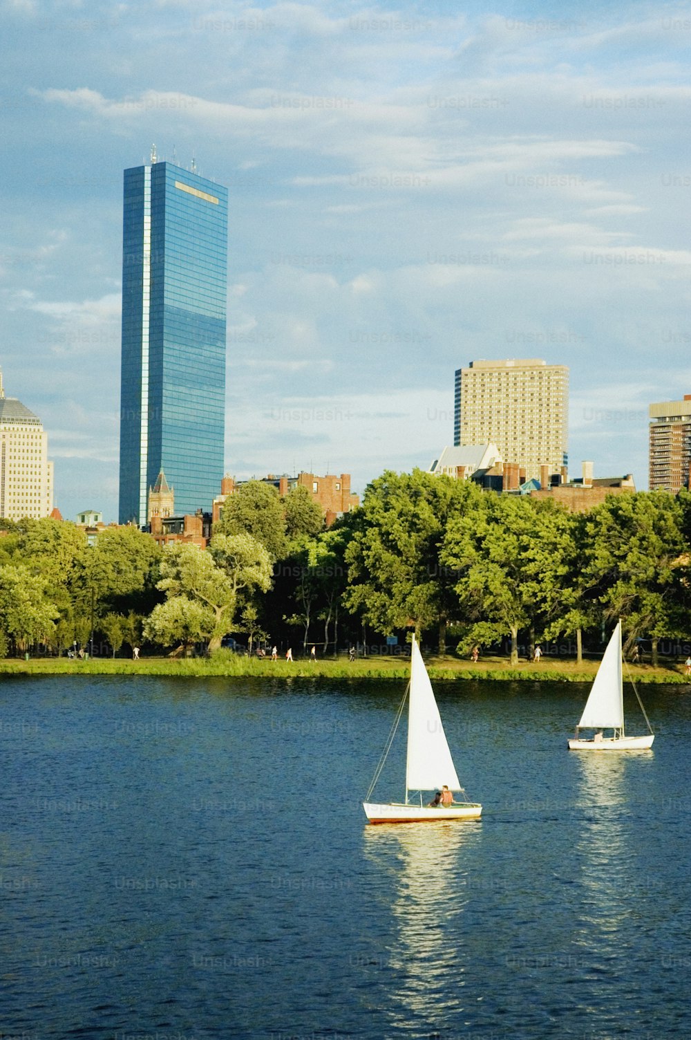 a couple of sail boats floating on top of a lake