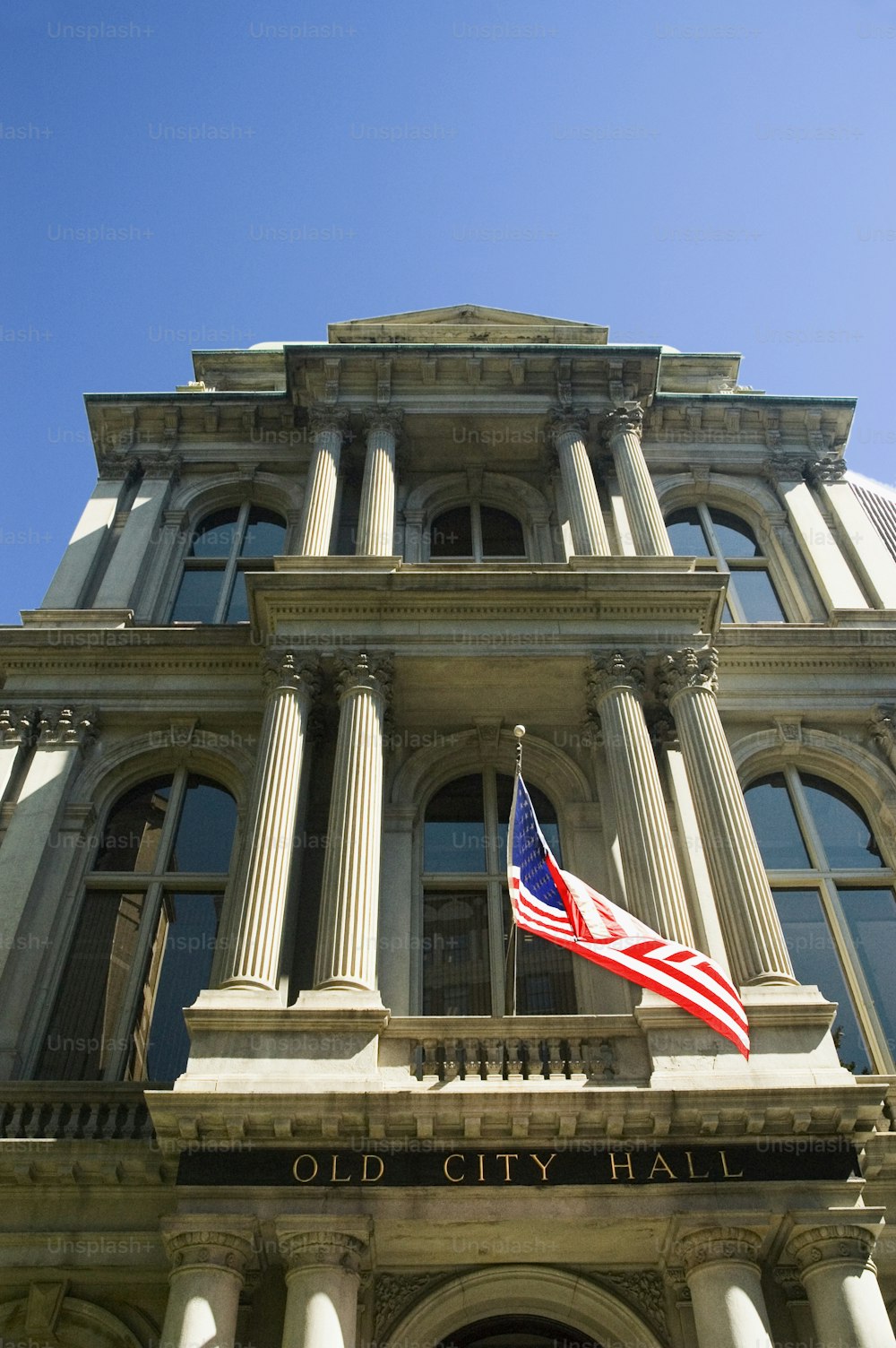 an old city hall with an american flag on top