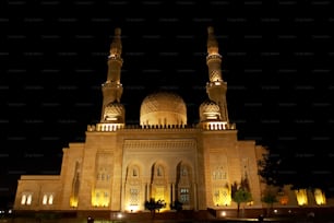 a large building lit up at night with lights on