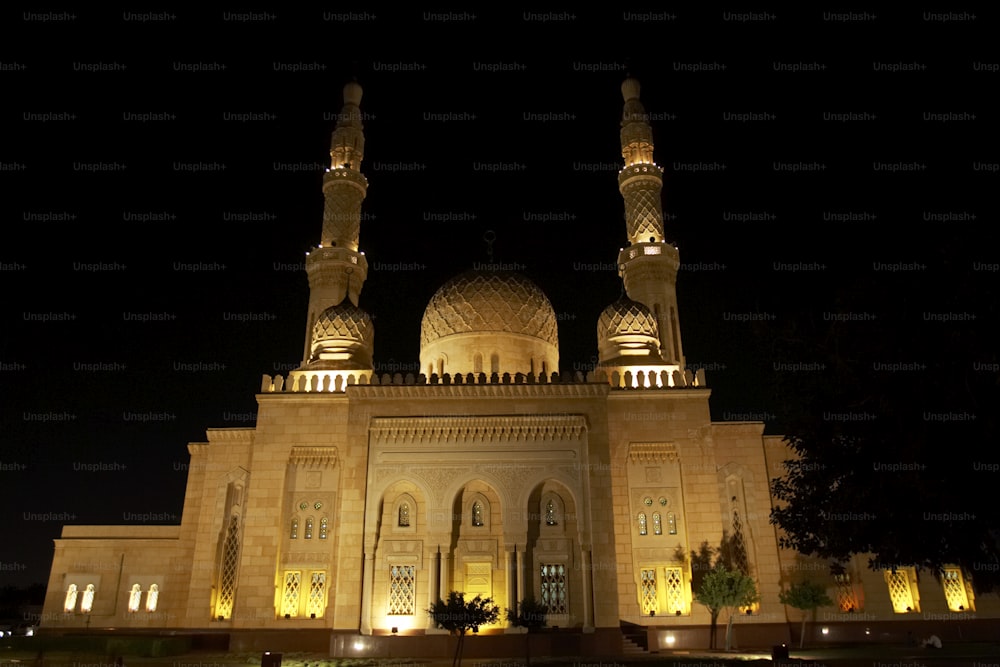 a large building lit up at night with lights on