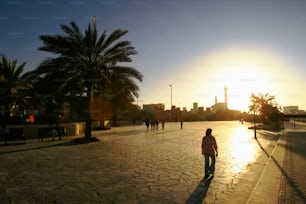 a man walking down a street next to palm trees