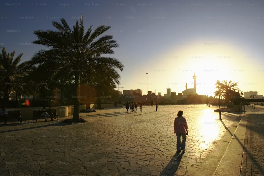 a man walking down a street next to palm trees