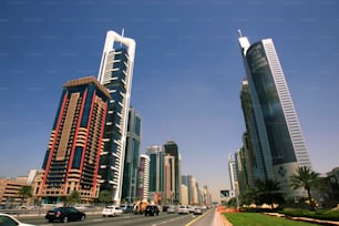 a city street with tall buildings in the background