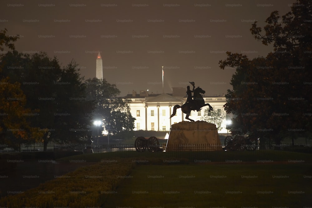 a statue of a man riding a horse in front of the white house