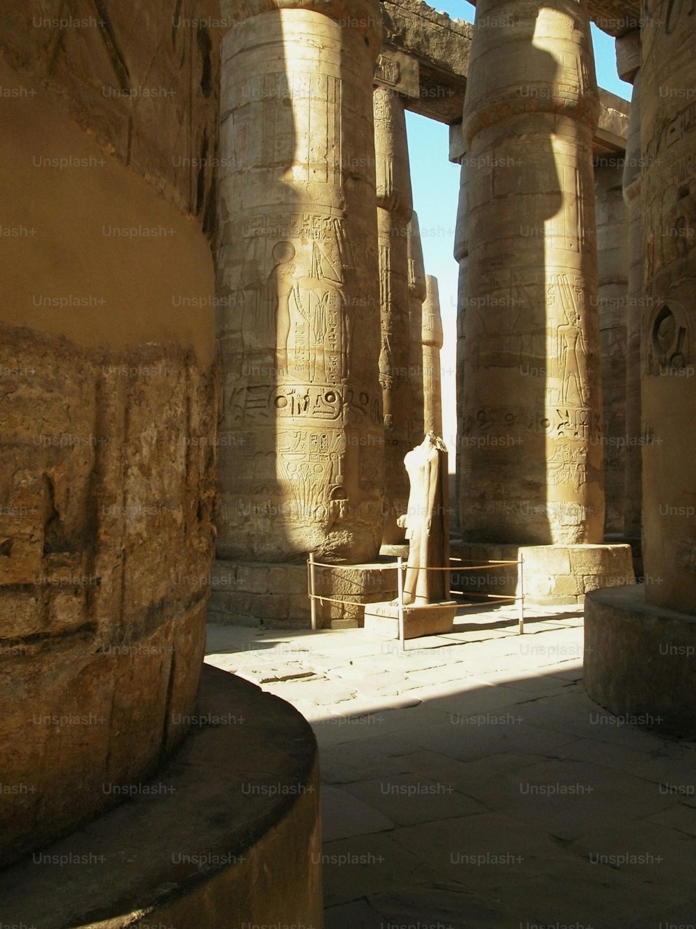 두 개의 큰 기둥 사이에 서있는 남자의 동상