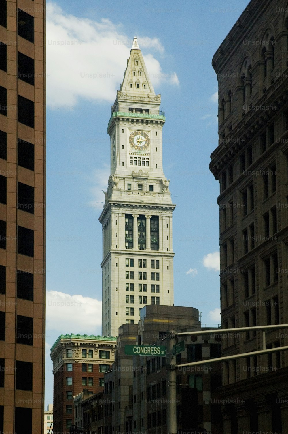 une haute tour d’horloge blanche dominant une ville