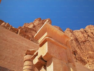 a large stone structure in front of a mountain