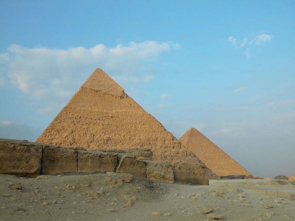the pyramids of giza are shown against a blue sky