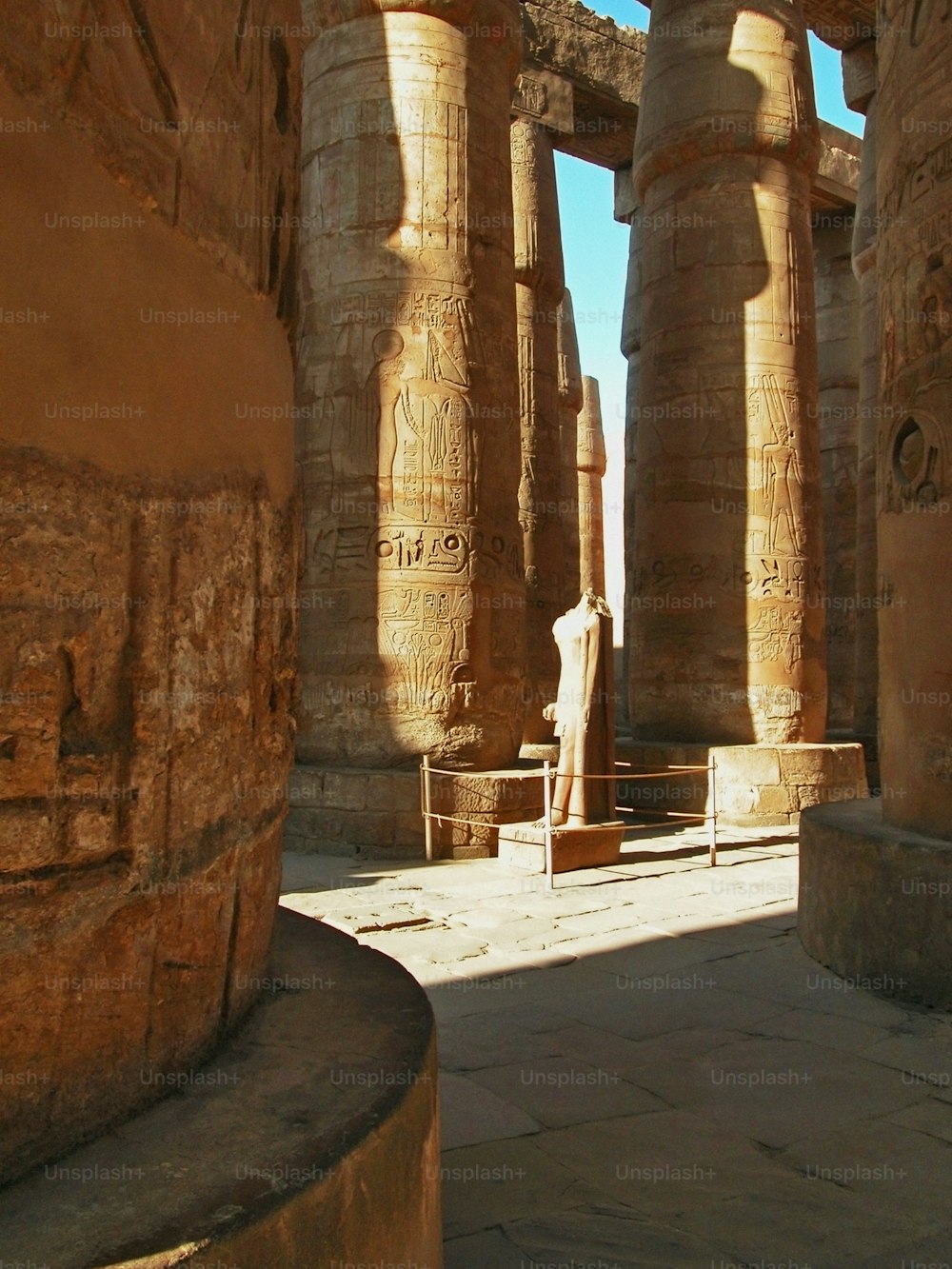 una statua di un uomo in piedi di fronte ad alcuni pilastri