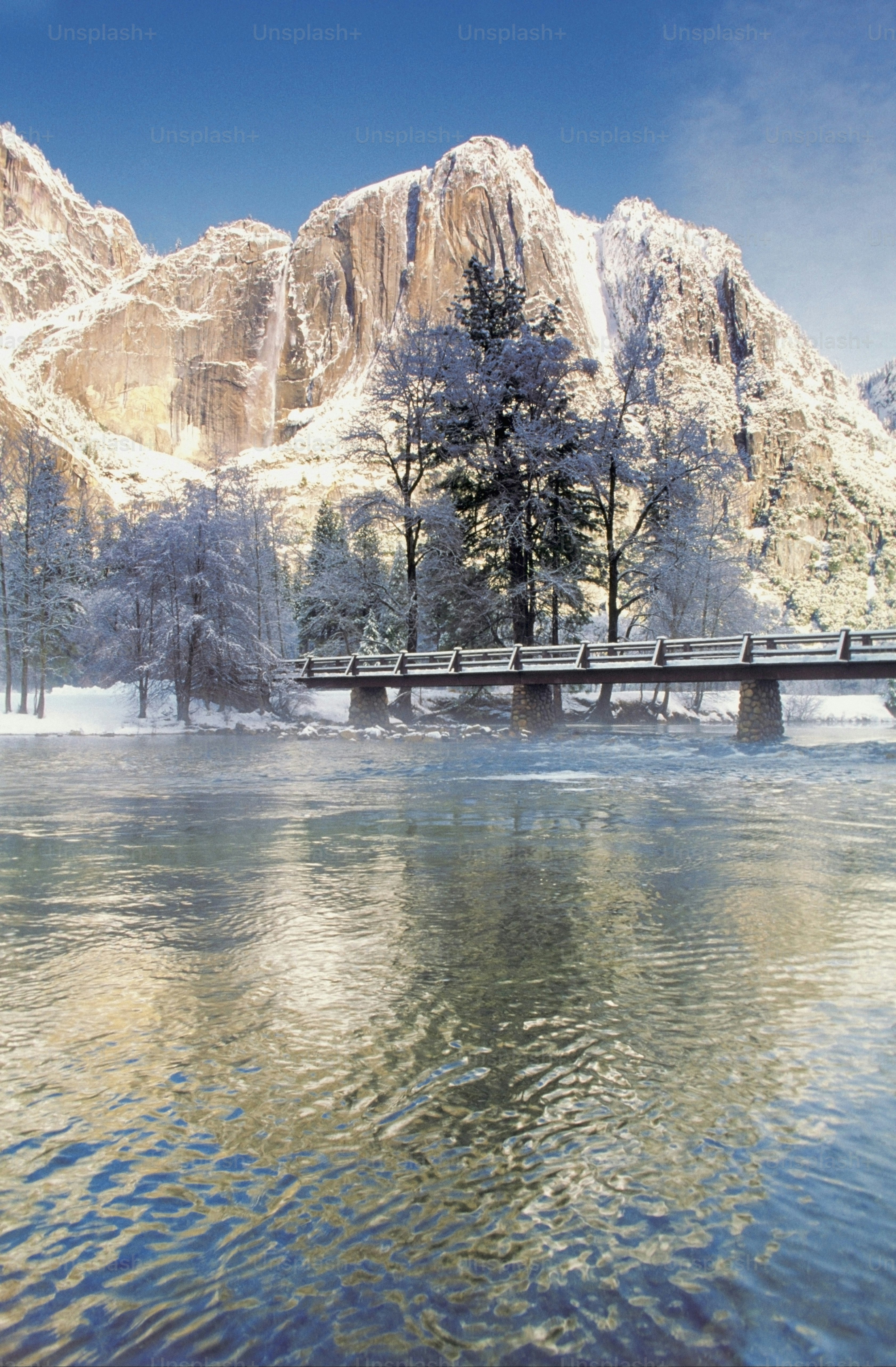 Un pont au-dessus d’un plan d’eau devant une montagne photo – L'eau ...