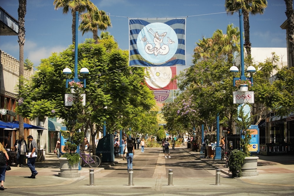 a street with palm trees and people walking on it