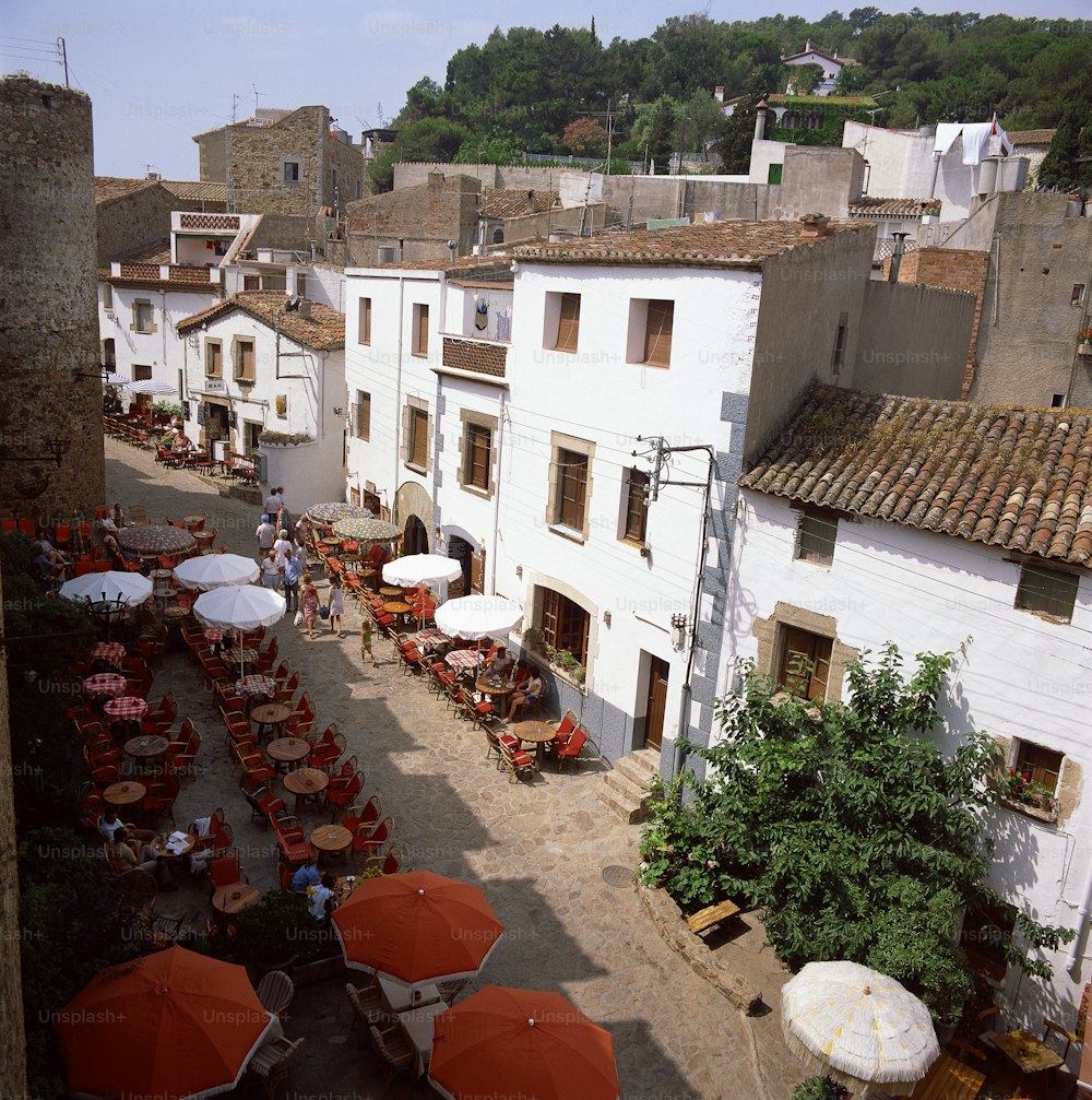 an aerial view of a courtyard with tables and umbrellas