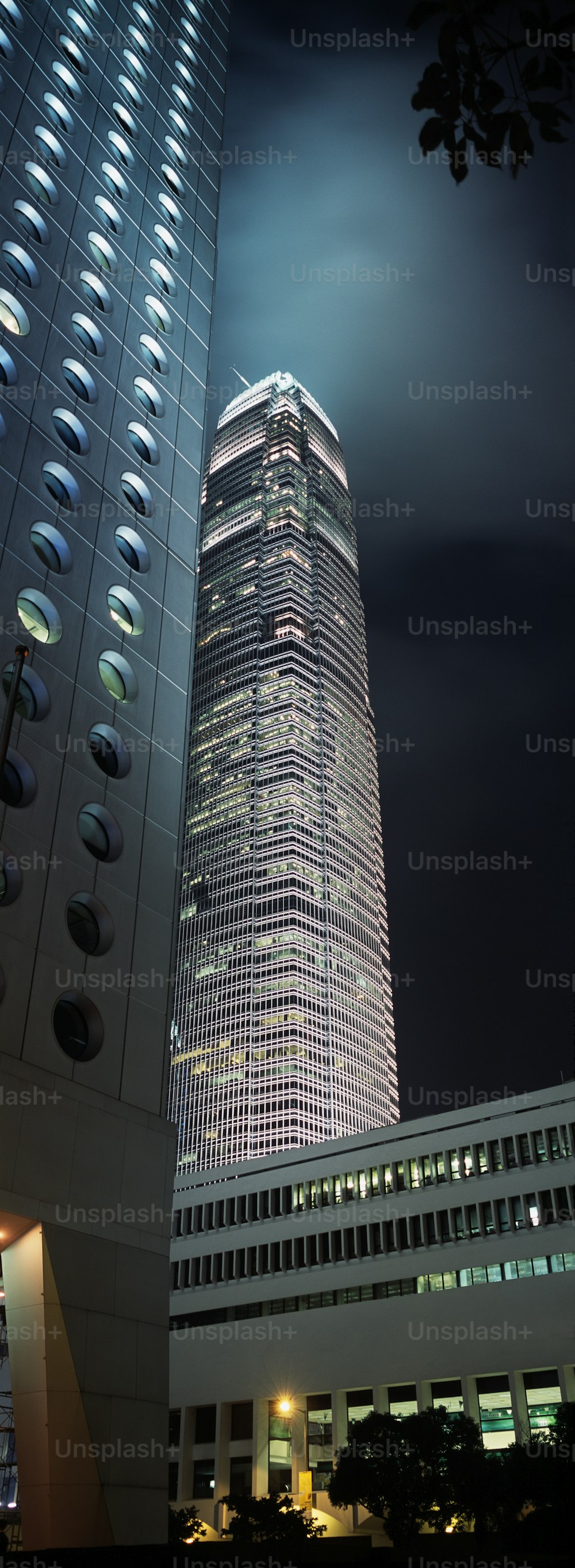 Ein hohes Gebäude, das nachts in einer Stadt beleuchtet wird