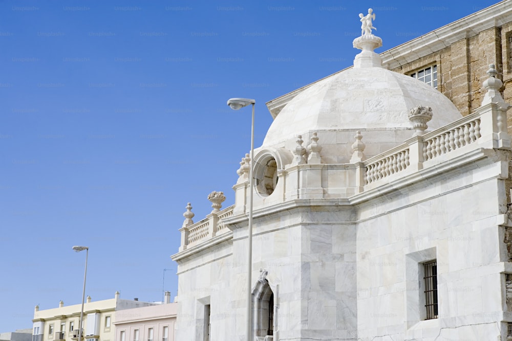 un grand bâtiment blanc avec une horloge sur le dessus