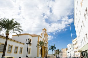 a white building with a yellow clock tower
