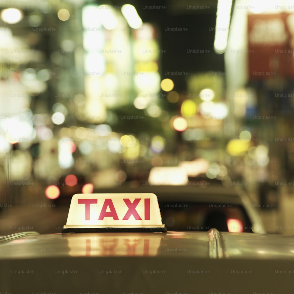 um sinal de táxi sentado no capô de um carro