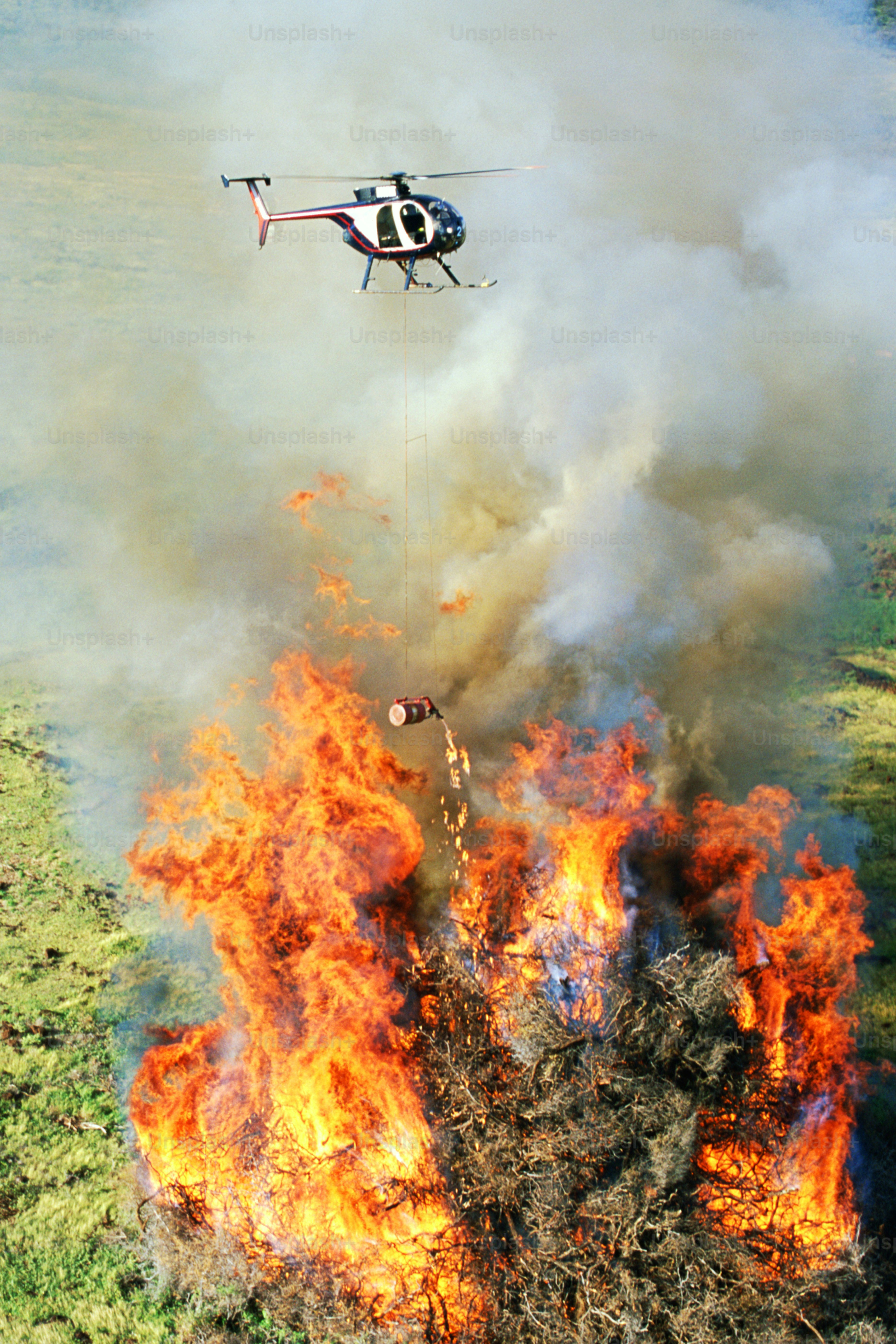 Un hélicoptère survole un grand incendie