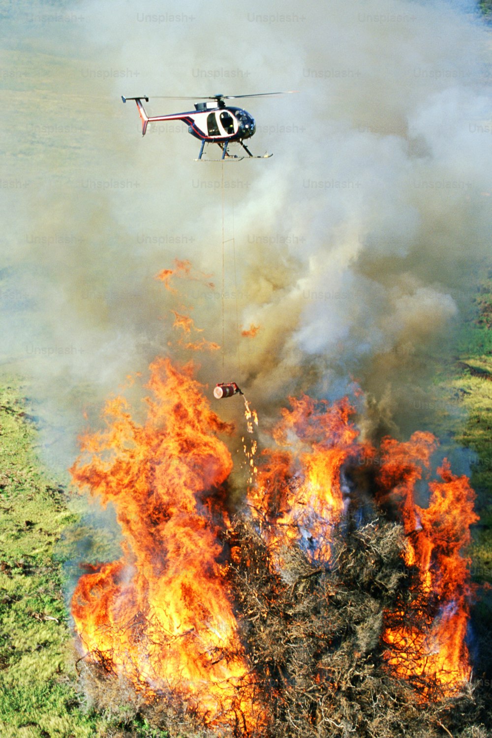 a helicopter is flying over a large fire