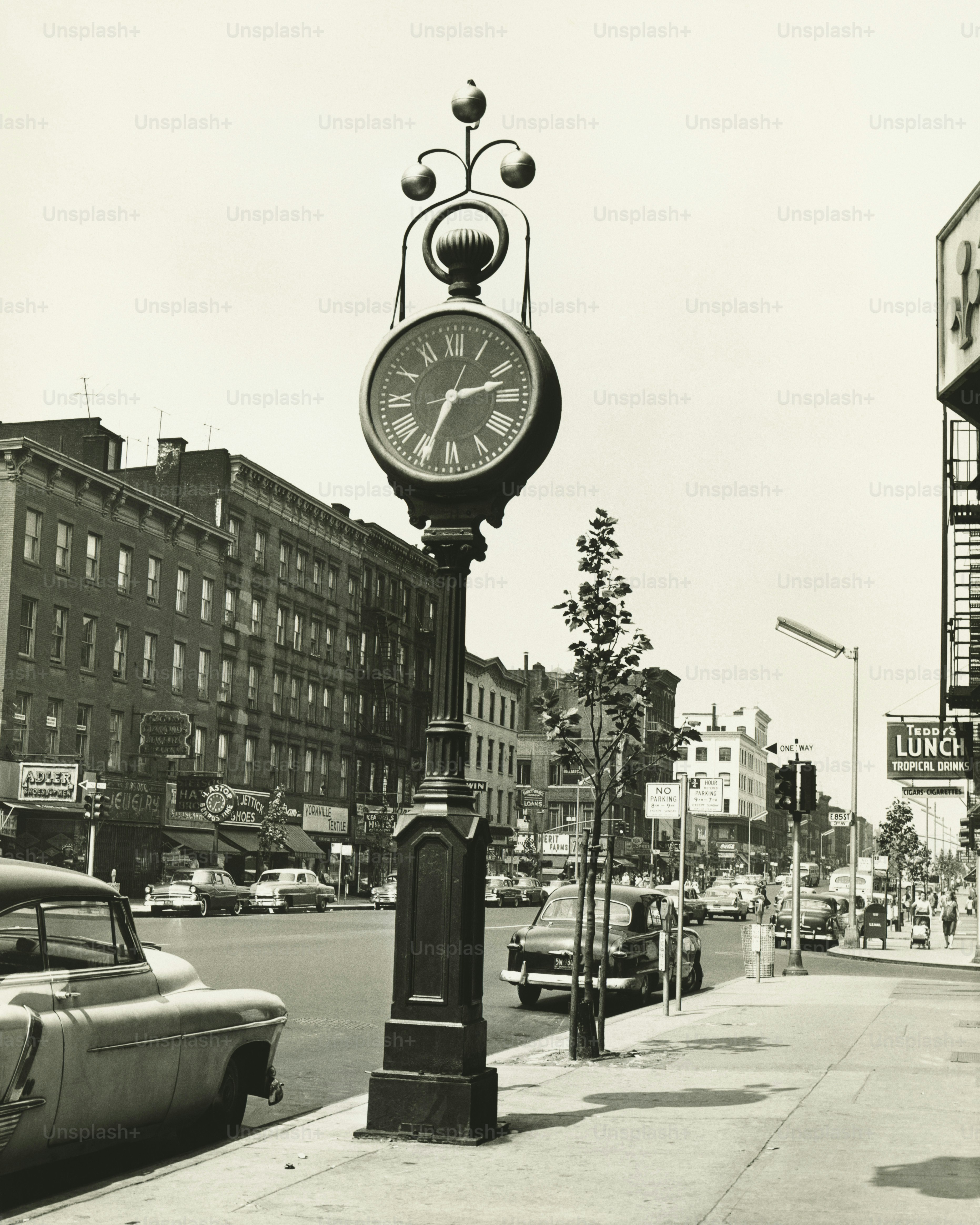a black and white photo of a clock on a pole