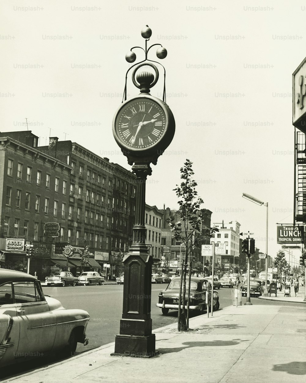 uma foto em preto e branco de um relógio em um poste