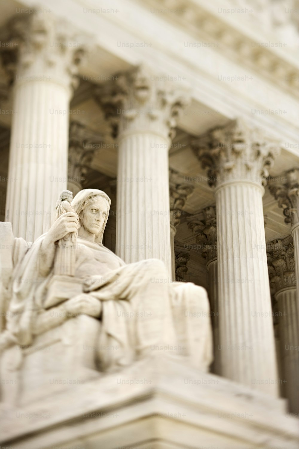 a statue of a woman sitting on a bench in front of a building