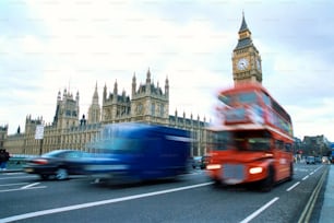 a red double decker bus driving past big ben