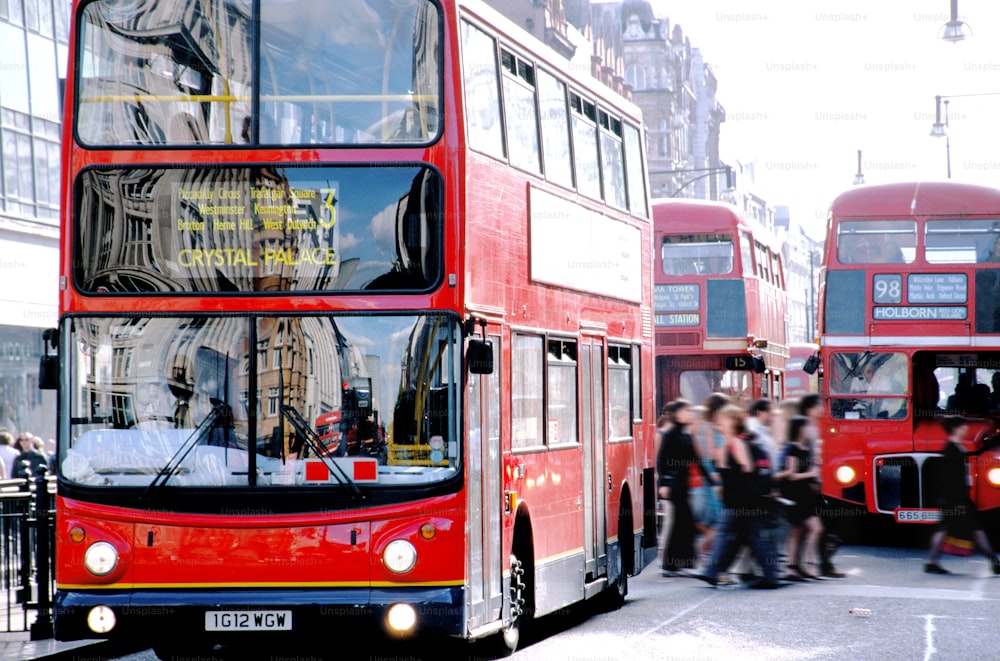 a red double decker bus driving down a street